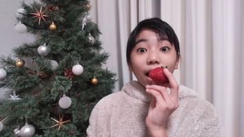 【写真】クリスマスツリーの前でポレポレ苺をたべようとしているあゆみちゃん